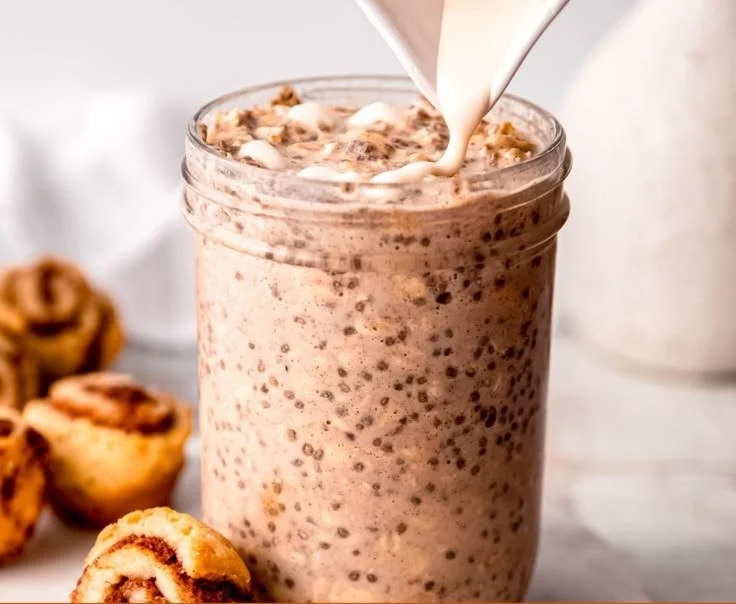Bowl of cinnamon roll overnight oats topped with nuts and cinnamon