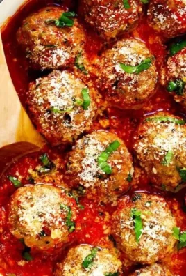 Plate of classic baked meatballs with marinara sauce and herbs
