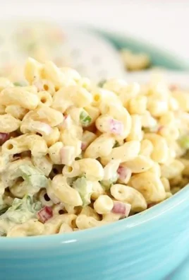 Classic macaroni salad with vegetables and dressing in a serving bowl