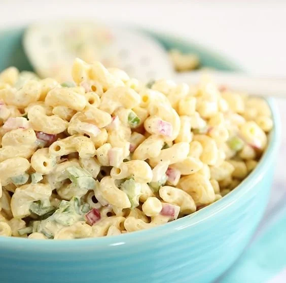 Classic macaroni salad with vegetables and dressing in a serving bowl