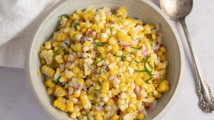 Colorful bowl of fresh corn salad with vegetables and dressing