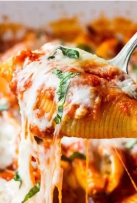 Cottage cheese stuffed shells topped with marinara sauce and herbs