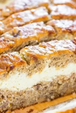 Slice of cream cheese-filled banana bread on a wooden cutting board