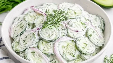 Delicious creamy cucumber salad served in a bowl with fresh herbs