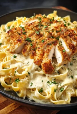 Plate of crispy chicken fettuccine alfredo topped with parsley