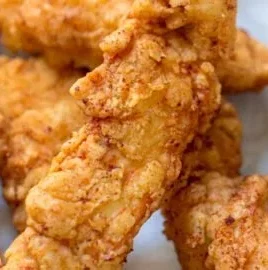 Crispy chicken tenders served with dipping sauce