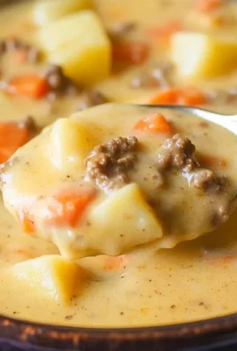 Delicious bowl of Crockpot cheeseburger soup topped with cheese and herbs