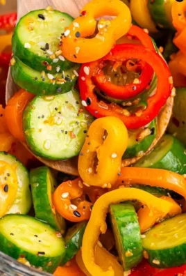 Cucumber and sweet pepper salad served in a bowl with fresh herbs.