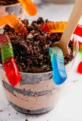 Delicious Dirt and Worms pudding cups decorated with gummy worms and chocolate crumbs