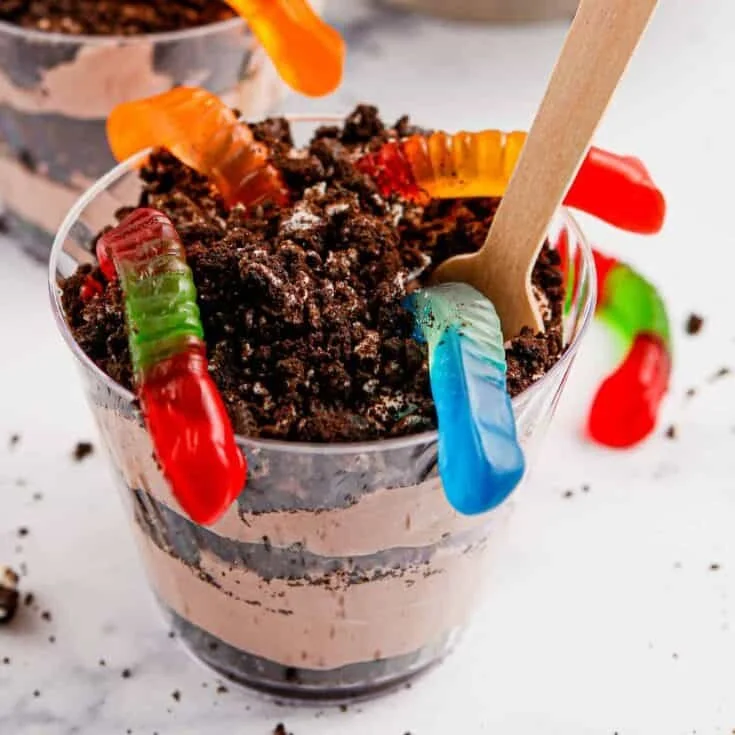 Delicious Dirt and Worms pudding cups decorated with gummy worms and chocolate crumbs
