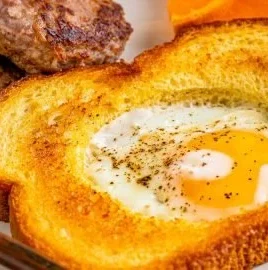 Delicious Egg in a Hole served on a plate with toast and spices