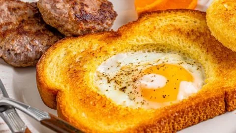 Delicious Egg in a Hole served on a plate with toast and spices