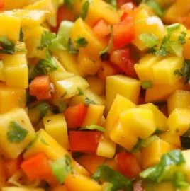 Bowl of fresh mango salsa with chopped vegetables and herbs
