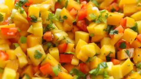 Bowl of fresh mango salsa with chopped vegetables and herbs