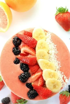 Grapefruit breakfast smoothie bowl topped with fresh fruits and seeds