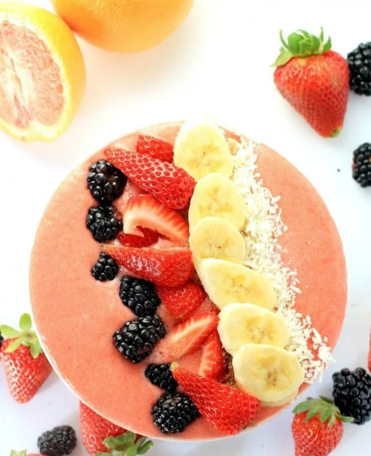 Grapefruit breakfast smoothie bowl topped with fresh fruits and seeds