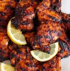 Delicious grilled BBQ chicken thighs on the barbecue grill