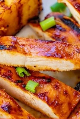 Hawaiian grilled chicken served with pineapple slices on a plate.