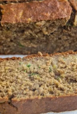 Slice of healthy oatmeal zucchini banana bread topped with nuts and banana slices