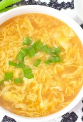 Bowl of homemade egg drop soup with green onions garnish