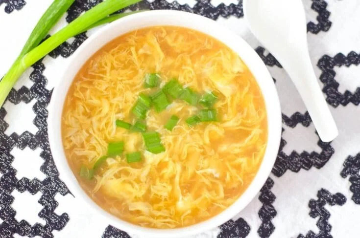 Bowl of homemade egg drop soup with green onions garnish