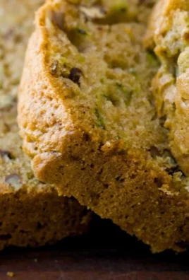 Loaf of homemade zucchini bread on a wooden cutting board