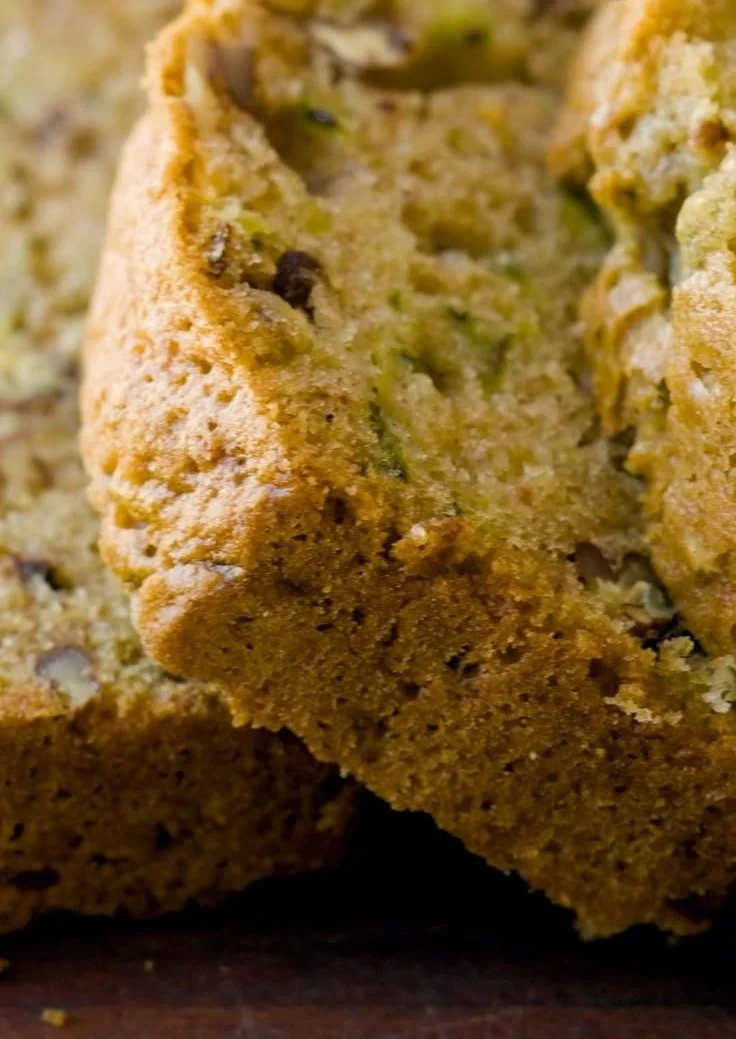 Loaf of homemade zucchini bread on a wooden cutting board