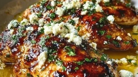Plate of Hot Honey Feta Chicken garnished with fresh herbs.