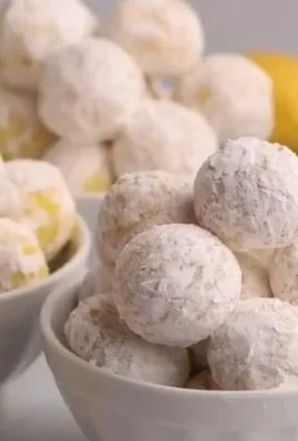 Delicious homemade Lemon Truffles surrounded by citrus zest and chocolate.