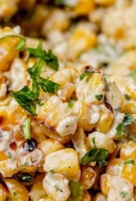 Bowl of colorful Mexican street corn salad with lime, cheese, and cilantro.
