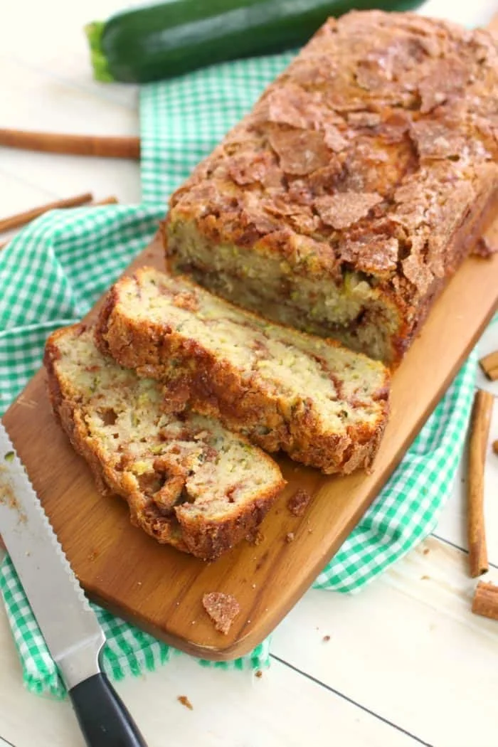 Moist and delicious cinnamon swirl zucchini bread slice on a wooden table
