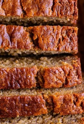 Slice of moist banana bread made with sour cream on a wooden table