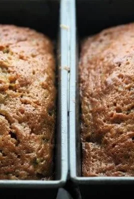Super-moist zucchini bread freshly baked and served on a wooden table