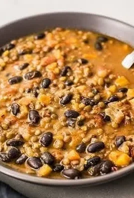 Bowl of protein-packed black bean and lentil soup garnished with herbs