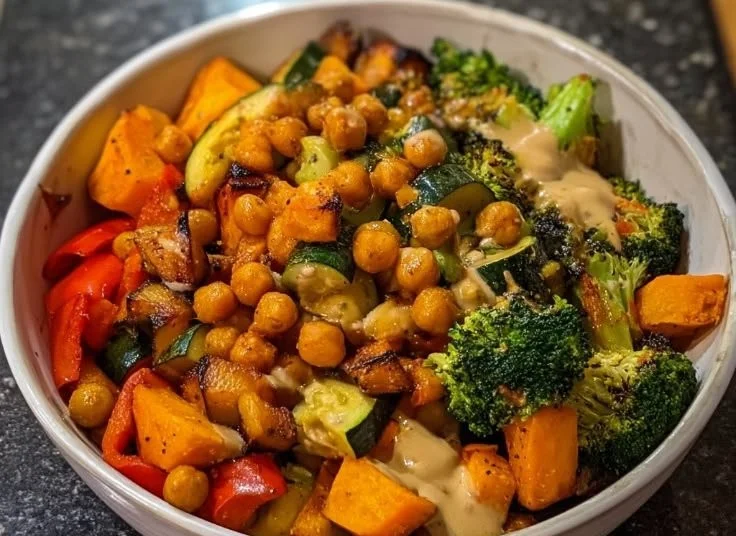 Colorful roasted veggie bowl with assorted vegetables and seasoning.