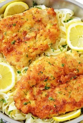 Romano chicken dish served with lemon garlic pasta on a plate