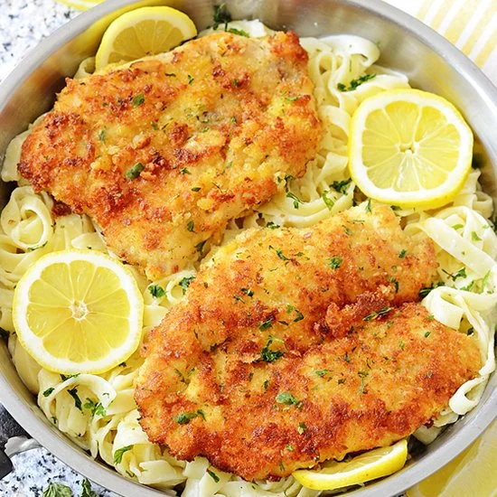 Romano chicken dish served with lemon garlic pasta on a plate
