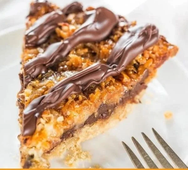 Samoa Pie topped with chocolate and coconut flakes, a rich dessert treat.