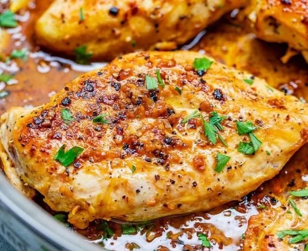 Plate of simple garlic butter chicken garnished with fresh herbs