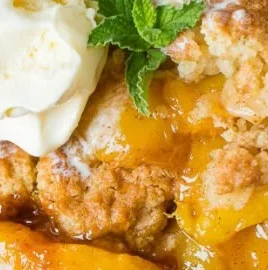 Delicious Southern Peach Cobbler served warm with a scoop of ice cream