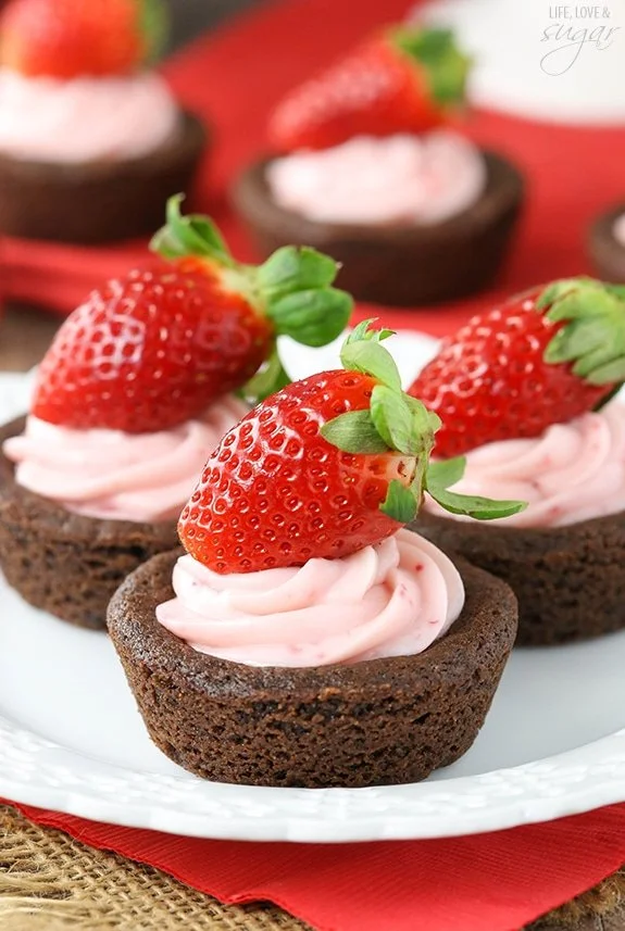 Strawberry cheesecake chocolate cookie cups displayed on a white platter