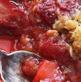 Delicious homemade Strawberry Crisp served in a bowl with fresh strawberries