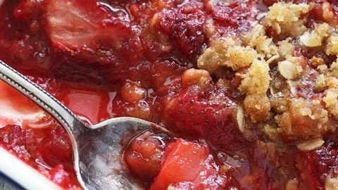Delicious homemade Strawberry Crisp served in a bowl with fresh strawberries