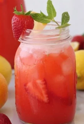A glass of refreshing strawberry lemonade with fresh strawberries and lemon slices