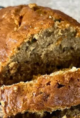Freshly baked zucchini bread with slices on a wooden cutting board.